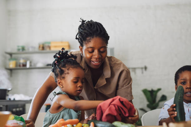 istock Mother, Daughter and Son Enjoy Preparing Vegetables for Lunch at a Kitchen Table 1310276851