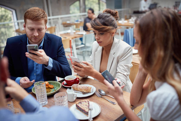 istock young people having unsocial lunch in restaurant, using their cell phones and not talking to each other. social issues, victims of modern technology 1310276893