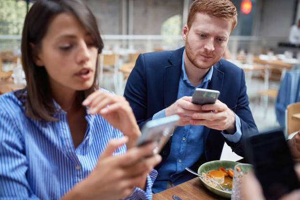 istock Young man and woman at business lunch texting message. 1310277660