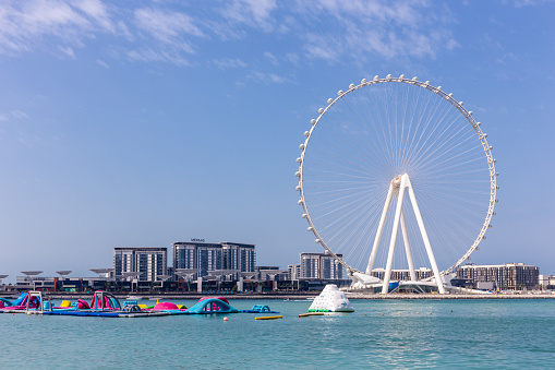 Dubai, UAE, 22.02.2021. Skyline of Bluewaters Island with Ain Dubai (Dubai Eye) tallest ferris wheel in the world and water bay with floating fun park.