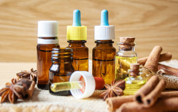 istock Essential oil bottle with cinnamon stick, star anise on wooden background. Selective focus 1310278092