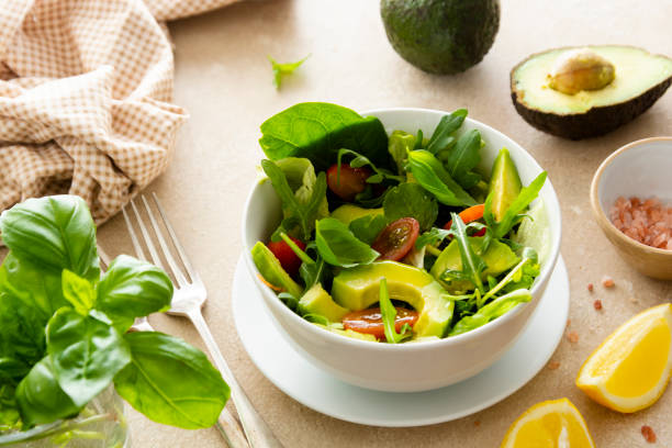 heathy sałatka z jedzeniem. sałatka ze szpinakiem z awokado z sokiem z cytryny i oliwą z oliwek. - heathy food zdjęcia i obrazy z banku zdjęć