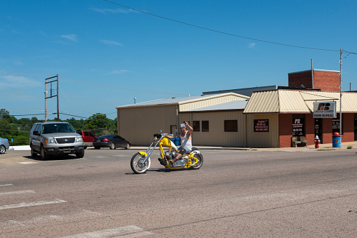 Oklahoma, USA - July 7, 2014: A biker riding a yellow chopper along the US Route 66, in the State of Oklahoma.
