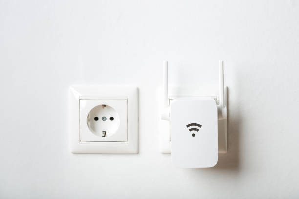 white wi-fi repeater indoors at home in outlet. wireless router white wi-fi repeater indoors at home in outlet. wireless router. rocket booster photos stock pictures, royalty-free photos & images