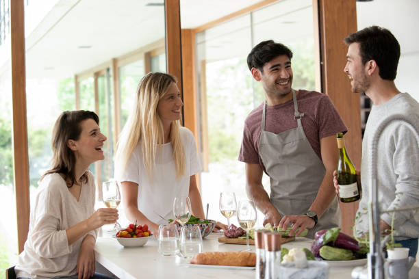 istock Smiling young friends having fun in kitchen while cooking 1310283461