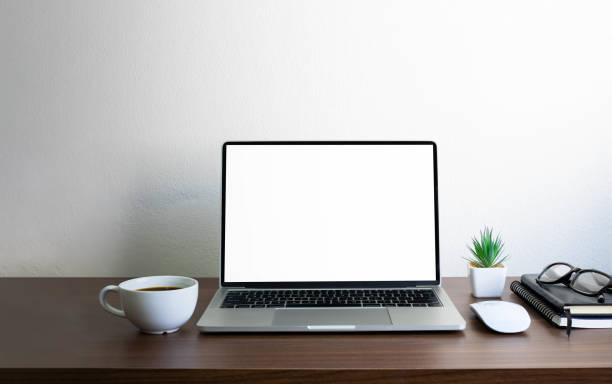 istock Laptop computer blank screen on wood office desk table with coffee cup and notebook, mouse computer with equipment office supplies. Business and finance concept. Workplace, Flat lay with copy space. 1310284743