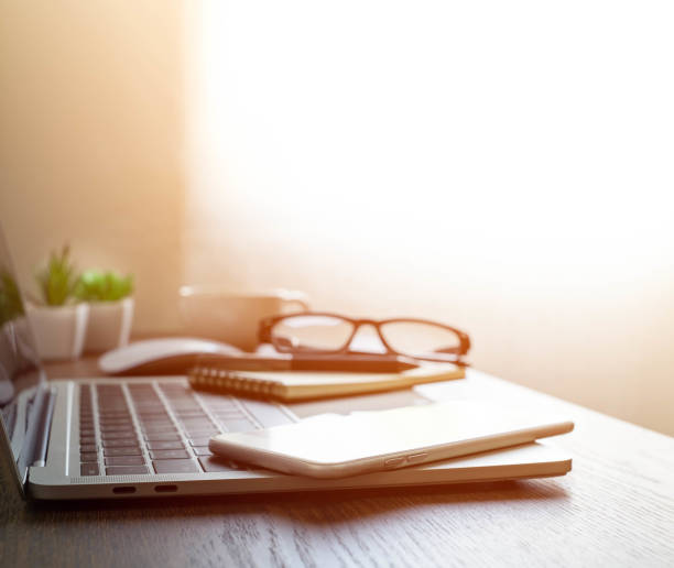 istock soft focus of Office desk table with keyboard of laptop computer, coffee cup and notebook, glasses. Business and finance concept. Workplace with morning sunlight from window with copy space. 1310284745