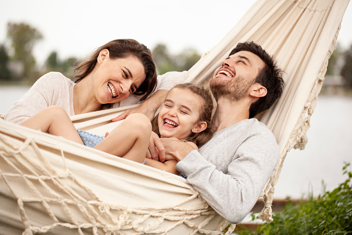 Familia sonriente divirtiéndose mientras yacía en una hamaca photo