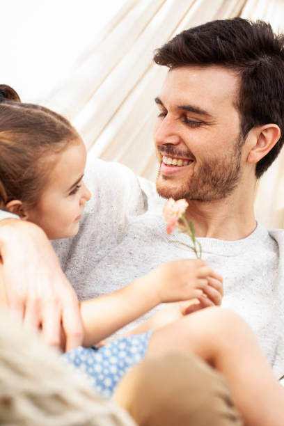 istock Smiling father and daughter looking at each other while lying in a hammock 1310284776