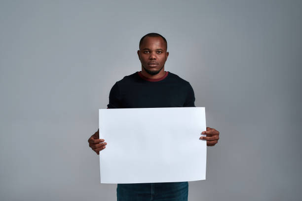 istock Calm african american man holding blank placard mockup 1310284922