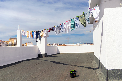 A lot of baby clothes drying on the roof in the city