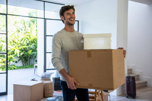 istock Man holding cardboard boxes in new house 1310289263