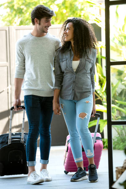 istock Couple walking with carry-on luggage 1310289379