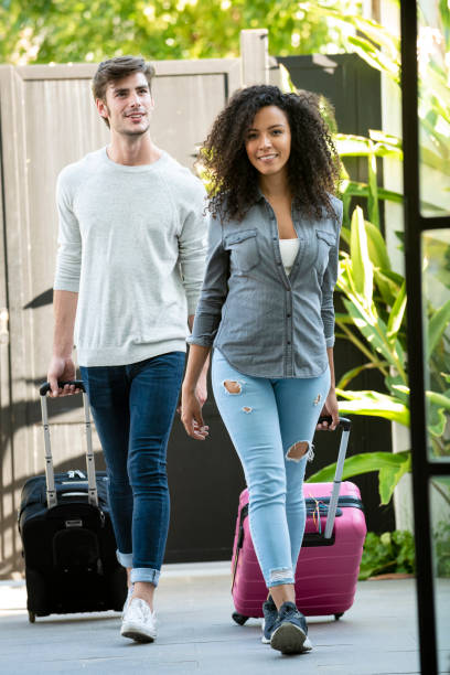 istock Couple walking with wheeled luggage 1310289438