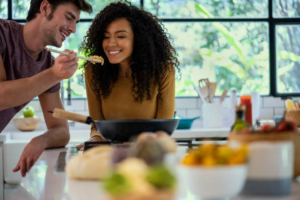 istock Smiling man feeding spaghetti to his wife 1310289624