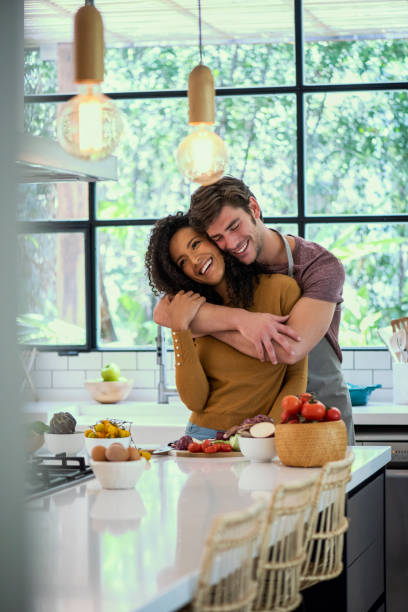 istock Smiling man embracing his wife in kitchen 1310289752