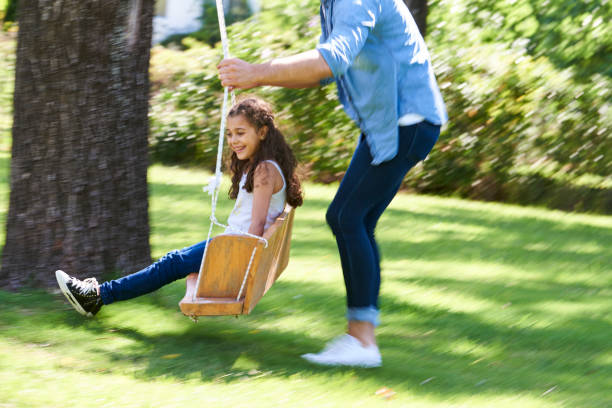 istock Father and daughter playing on the swing in garden 1310289909