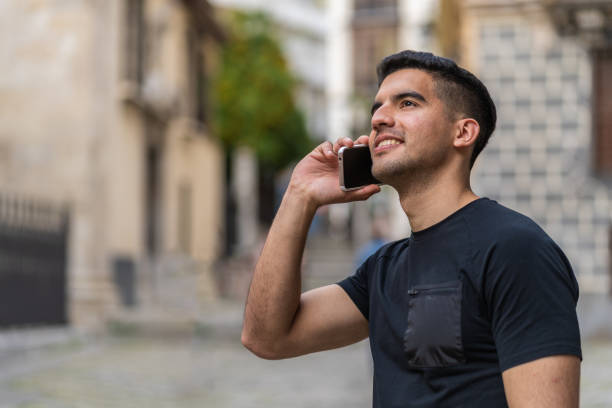 Young Latin man with a dark complexion talking with the smartphone stock photo