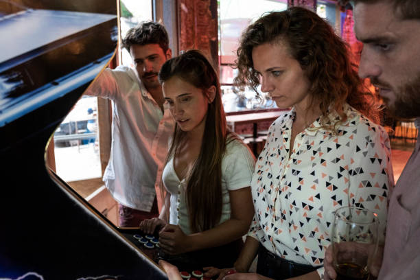 istock Young friends playing on arcade game machine at nightclub 1310291907