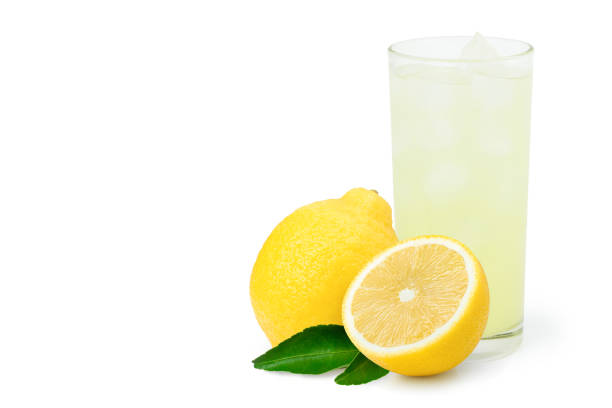 zitronensaft oder limonade mit frischen gelben limonfrüchten und grünem blatt auf weiß isoliert - lime fruit citrus fruit portion stock-fotos und bilder