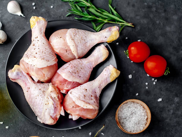 istock raw chicken legs with spices on a black plate on a stone background 1310292060