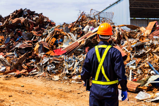 istock Engineer wearing protective equipment and holding computer tablet and looking at scrap metal recycle. 1310293077