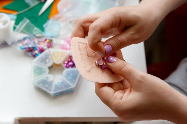 manos, una mujer hace un broche de cuentas y cristales - bead glass making jewelry fotografías e imágenes de stock