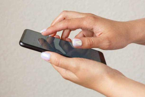 istock girl holds smartphone in hands on a light background 1310295489