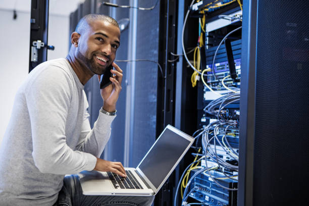 ein schwarzer männlicher serverraumtechniker, der bei der wiedereröffnung von business arbeitet - network server rack computer black stock-fotos und bilder