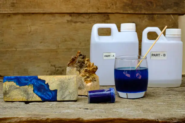 Timber burl woodchips color bottle and resin epoxy for casting wood on old wooden table background