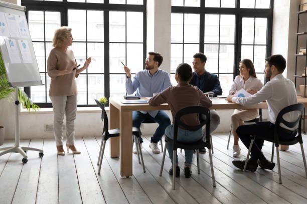 istock Middle-aged businesswoman talk make whitebeard presentation at meeting 1310305866