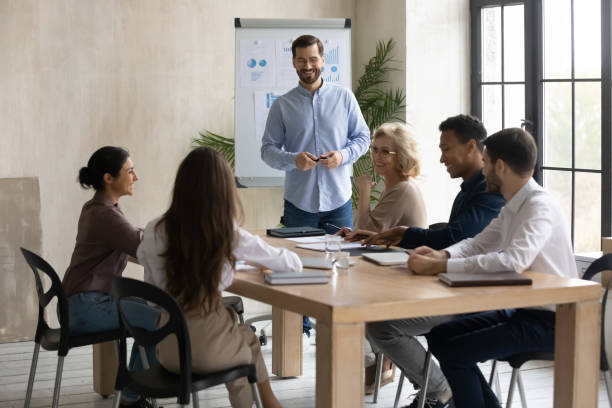 istock Smiling male trainer present project to colleagues at meeting 1310305871