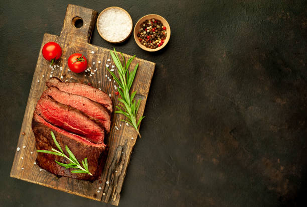 istock Grilled beef steak with spices on stone background with place for text 1310306454