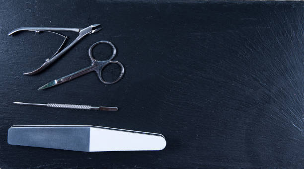istock Collection manicure tools on black stone background. Scissor, pusher, polisher and clipper 1310307116