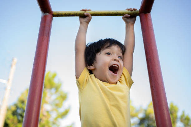 Happy asian Japanese little boy playing in playground with yellow t-shirt stock photo