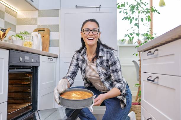 istock Woman at home in kitchen taking out hot apple pie from oven 1310310814
