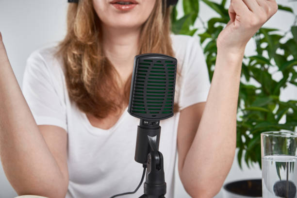 istock Woman recording online podcast at home. Microphone on table. home studio workplace 1310310909