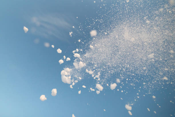 istock snow splash in the air, blue sky background 1310313276