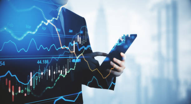 金融チャートグラフとローソク足とデジタルタブレットと仮想画面との取引と投資コンセプトのトレーダーのシルエット。 - 金融と経済 ストックフォトと画像
