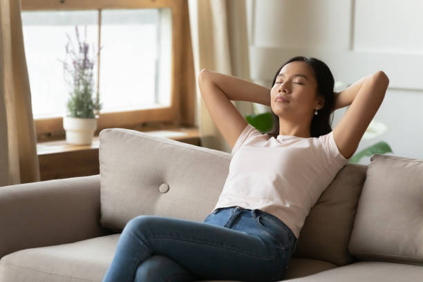 istock Relaxed young Asian woman resting on cozy sofa alone 1310323605