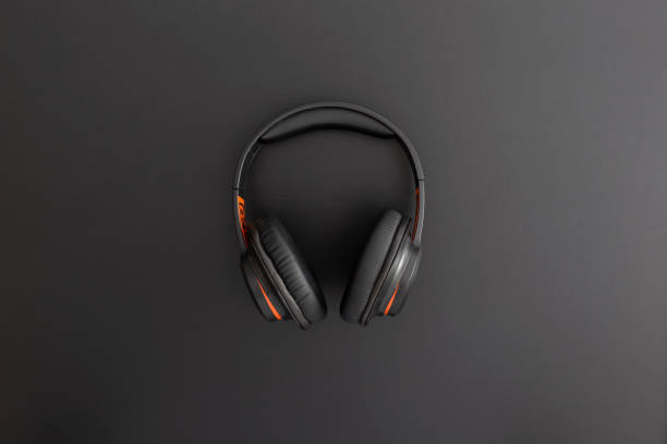istock Headphones on black leather background. Music concept. Flat lay composition. Top view. 1310324896