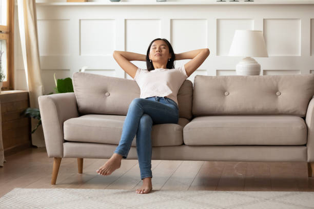 istock Peaceful young vietnamese woman daydreaming on sofa. 1310325646