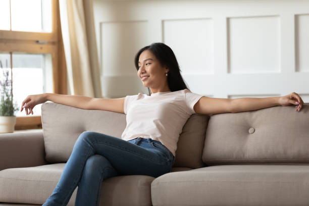 istock Happy beautiful vietnamese woman resting on sofa. 1310325648