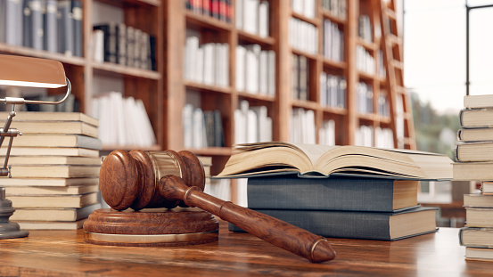 Law books and a gavel on the desk in the library.