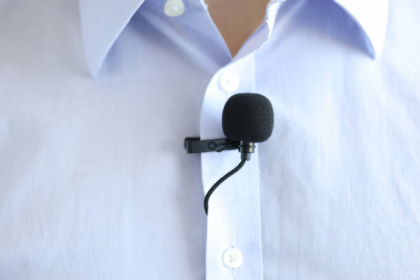 istock Black small microphone attaching to man shirt closeup 1310332379