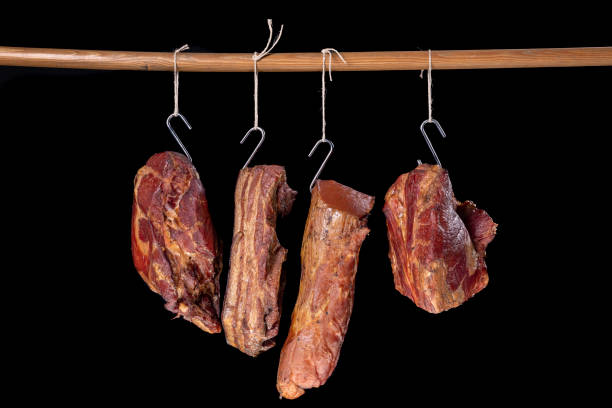 вкусное копченое мясо, подвешенное на веревке. мясо готовится по домашнему рецепту. темный фон. - garlic hanging string vegetable стоковые фото и изображения