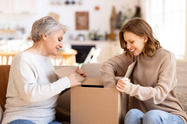 excited mother and daughter unpacking carton box - 16637 imagens e fotografias de stock