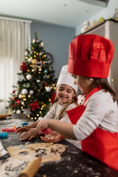 istock Selective focus of two little girls making gingerbread cookies 1310338549