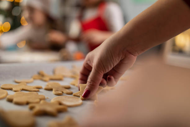 istock Female hand arranging cut out cookies on a baking sheet 1310338582