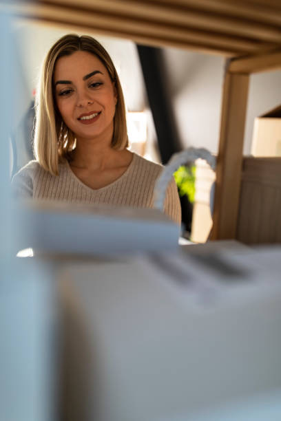 istock Young woman arranging packages she prepared on a shelf 1310340510